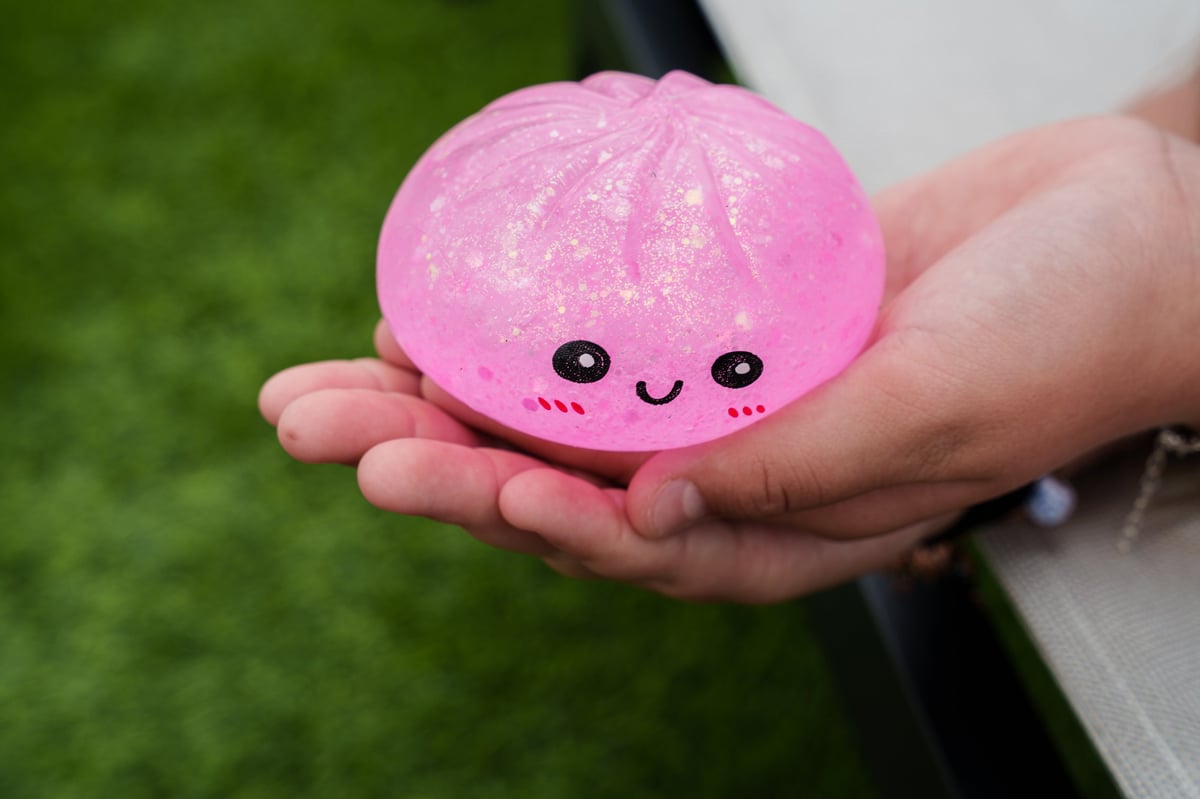 A child holding a pink glitter dumpling squishy fidget toy